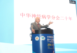 Figure 1. WFN President Raad Shakir speaking during the opening speech at the 20th Chinese Neurological Society congress. The banner on screen reads:  